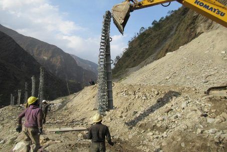 Excavator placing a barrier post on the Bhotekoshi slope