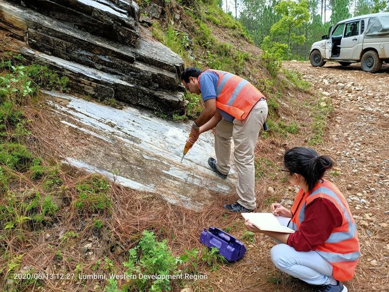 GSI geologists logging a rock outcrop beside a mountain road