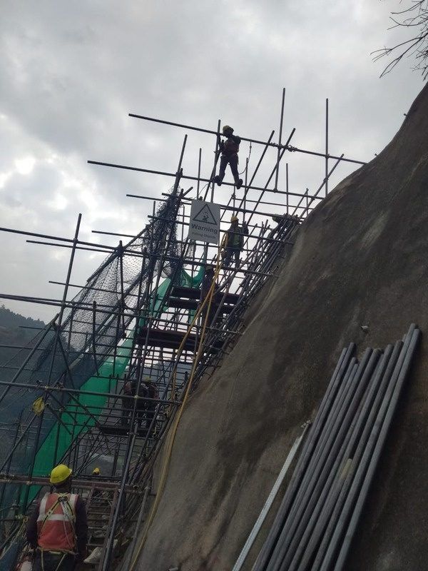 GSI crew on scaffolding installing protection on a rock face
