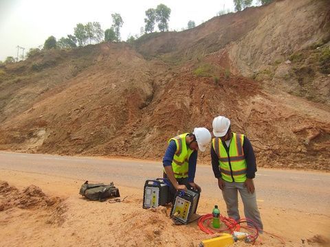 Engineers running a geophysical survey beside a landslide